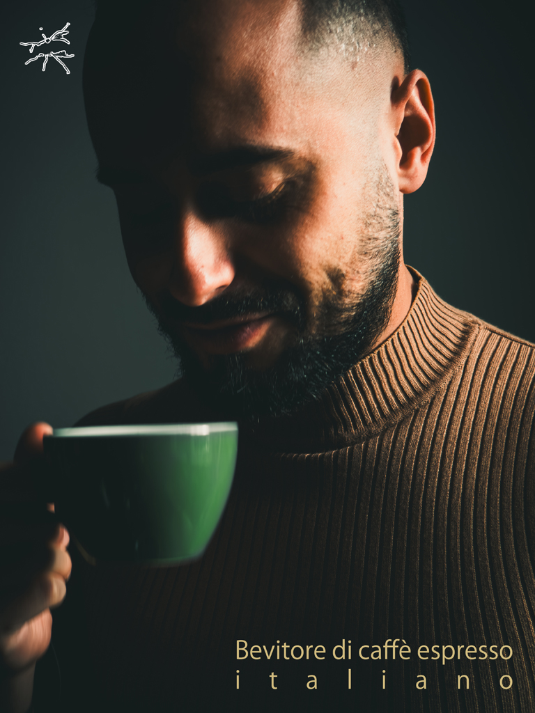 Deutsch:
Ein Mann hält eine grüne Espressotasse nah an seinen Lippen. Sein Gesicht liegt größtenteils im Schatten, nur Nase und Wange fangen das sanfte Licht. Sein brauner, gerippter Pullover wirkt warm, der Hintergrund ist ruhig und schlicht. Sein kaum sichtbares Lächeln spiegelt den Moment – Genuss, Zeit und Verbindung.
English:
A man holds a green espresso cup close to his lips. His face is mostly in shadow, with soft light catching his nose and cheek. His ribbed brown sweater radiates warmth, while the muted gray background fades into quiet simplicity. His faint smile reflects the moment—pleasure, time, and connection.
