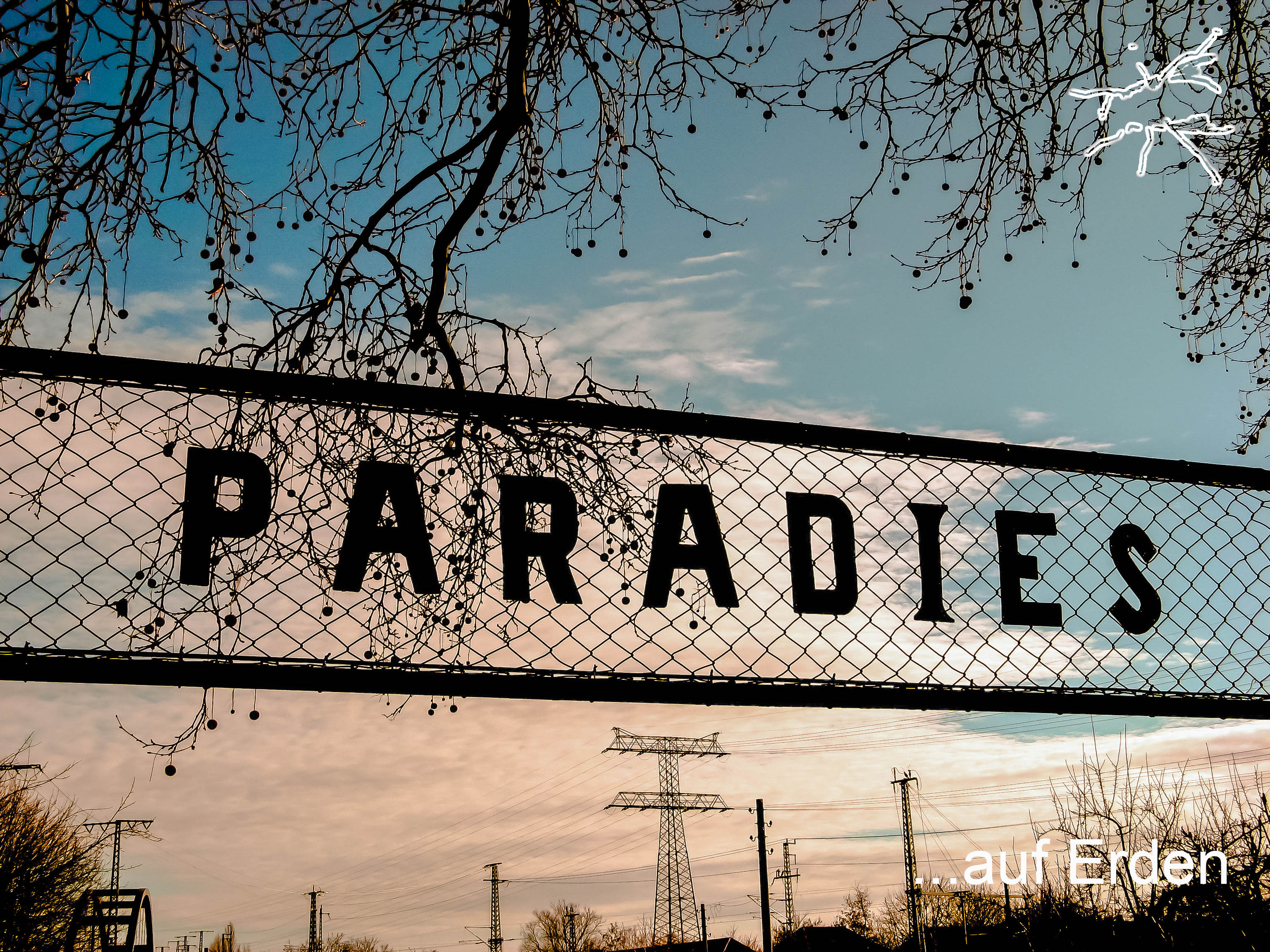 DE: Zaunschild mit der Aufschrift „Paradies“ vor Himmel, Strommasten und kahlen Bäumen. EN: Fence sign reading “Paradies” against a sky with power lines and bare trees.