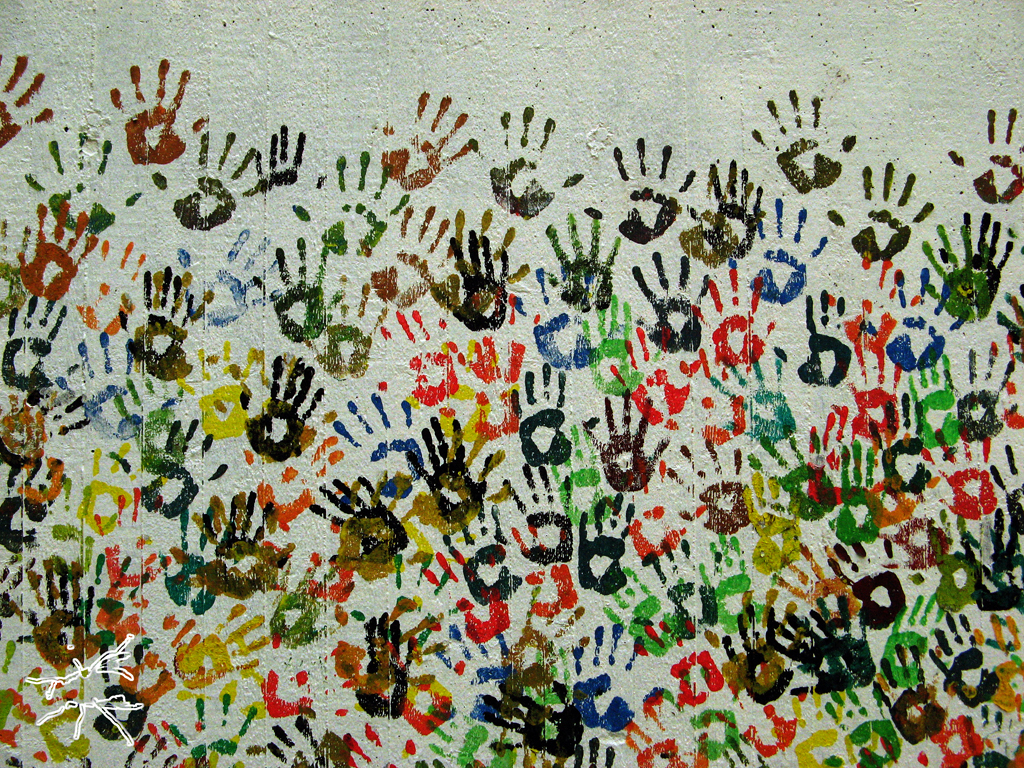 Deutsch:
Eine grüne Wand voller bunter Handabdrücke in verschiedenen Schichten. Manche klar erkennbar, andere überlagert – wie Spuren gelebter Momente. Die Farben mischen sich, verbinden sich, als Zeichen von Gemeinschaft und Zusammenhalt.
Englisch:
A green wall covered with colorful handprints in overlapping layers. Some distinct, others blending – like traces of shared moments. The colors merge, connecting in a symbol of community and togetherness.