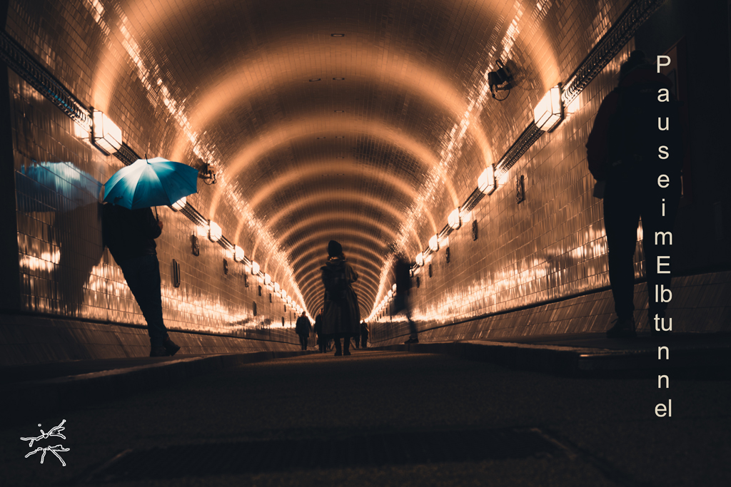 Deutsch:
Sanftes Licht spiegelt sich auf den glänzenden Kacheln des Elbtunnels. Ein Mann lehnt an der Wand, seine Silhouette fast eins mit der Struktur. Schatten und Licht fließen in leichten Wellen, während die Zeit stillzustehen scheint.
English:
Soft light reflects on the glossy tiles of the Elbe Tunnel. A man leans against the wall, his silhouette blending with the structure. Shadows and light ripple gently, as if time itself has paused.