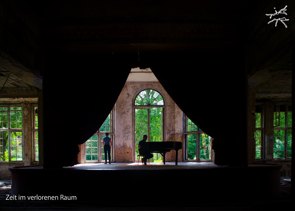 (DE) Verlassener Bühnenraum mit geöffnetem Vorhang, einem Flügel und zwei stillen Figuren vor hohen Fenstern im Grünen. (EN) Abandoned stage space with an open curtain, a grand piano, and two still figures facing tall windows and greenery.