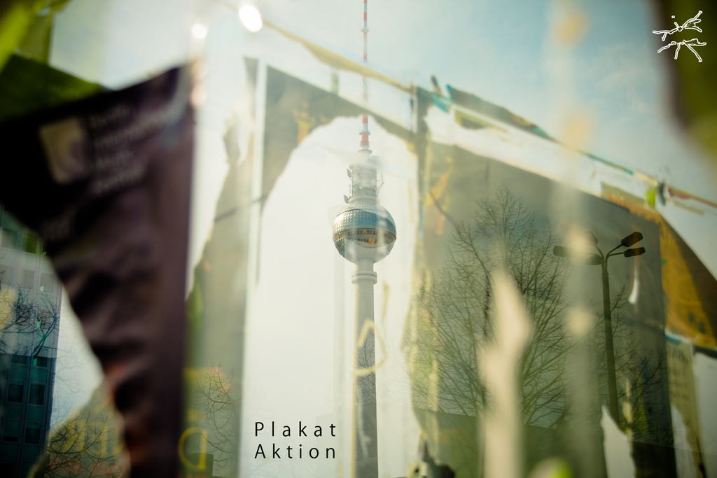 Deutsch:
Der Berliner Fernsehturm spiegelt sich in einer Schaufensterscheibe, umrahmt von den Überresten abgerissener Plakate. Vergänglichkeit trifft auf Beständigkeit – während die Poster verblassen, bleibt das Wahrzeichen bestehen.
English:
The Berlin TV Tower reflects in a storefront window, framed by remnants of torn posters. Ephemerality meets permanence—while the posters fade, the landmark remains.