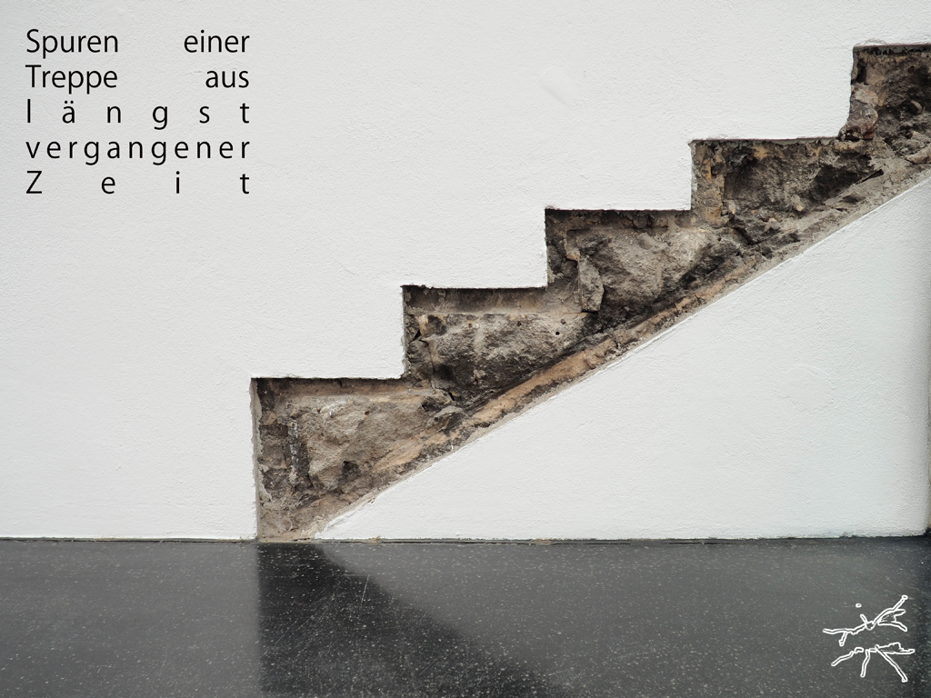 Freigelegte Stufenreste einer ehemaligen Treppe im weißen Putz – sichtbare Spur architektonischer Vergangenheit.