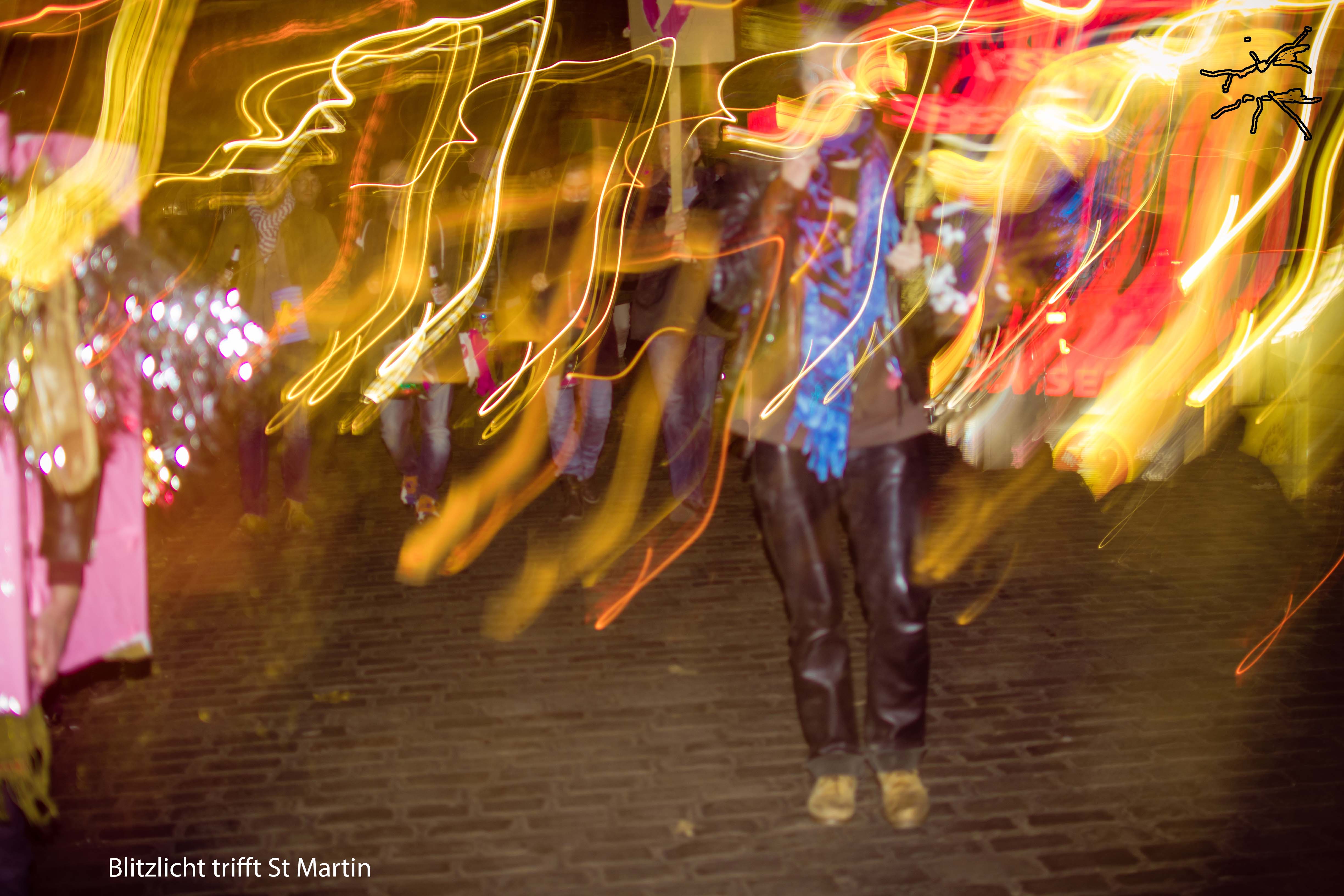 Langzeitbelichtung bei einer St. Martin Prozession mit leuchtenden Laternen und viel Bewegung. Long exposure photograph of a St. Martin's Day procession with glowing lanterns and a lot of movement.