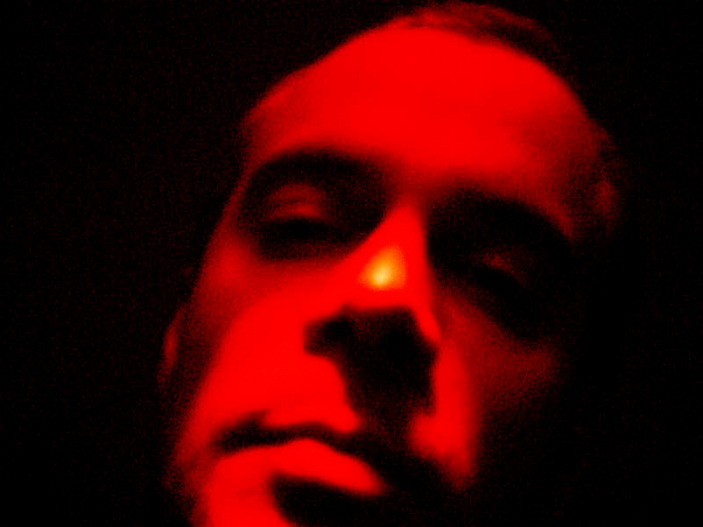 Ein verzerrtes Selbstporträt in Rot und Grün. Das Gesicht scheint aus Licht und Schatten zu entstehen, als würde es sich in der Farbe auflösen. Der Text reflektiert Bewegung, Wahrnehmung und das Zusammenspiel von Nähe und Distanz. English: A distorted self-portrait in red and green. The face appears to emerge from light and shadow, dissolving into color. The text reflects movement, perception, and the interplay of closeness and distance.