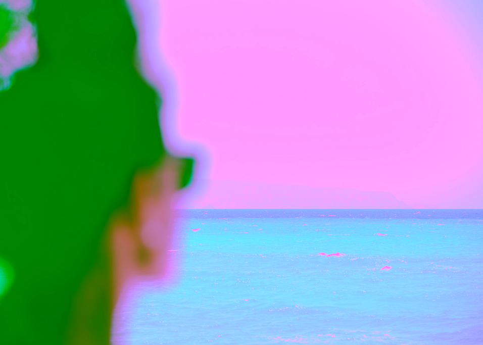 Unscharfe Person blickt über ein türkisfarbenes Meer – ein stiller Moment zwischen Wahrnehmung und Weite